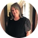 Circular portrait of a smiling maker with shoulder-length gray-blond hair in a black polka-dot-sleeve top