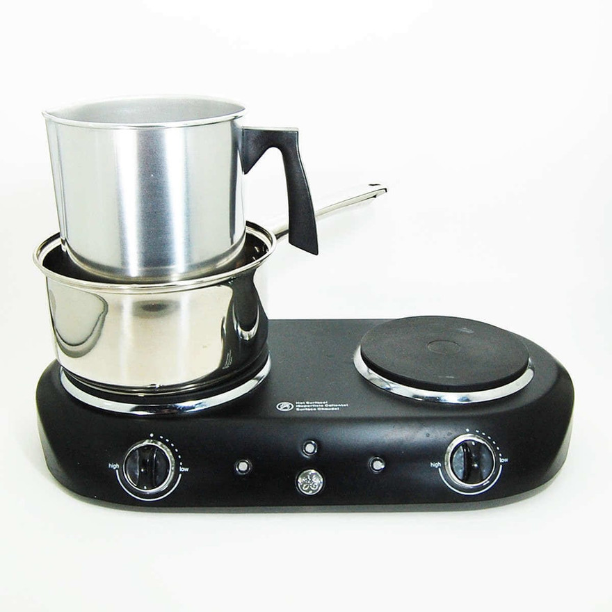 Aluminum pouring pitcher set in a steel pan as a double boiler on a black two-burner GE hot plate
