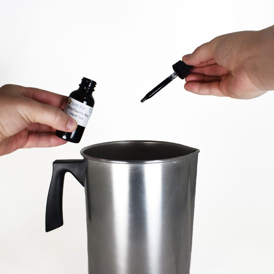 Hands holding Lone Star Navy/Country Blue liquid dye bottle and dropper over a steel pouring pot
