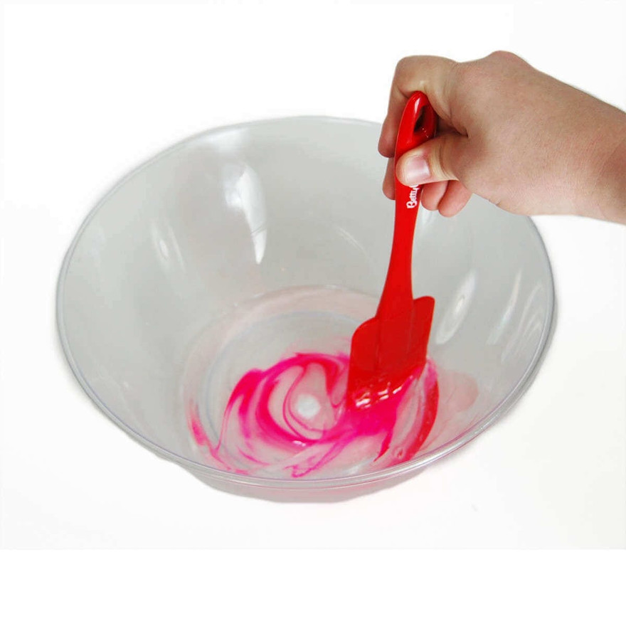 Hand stirring pink color into clear glue with a red spatula, swirling in a plastic bowl