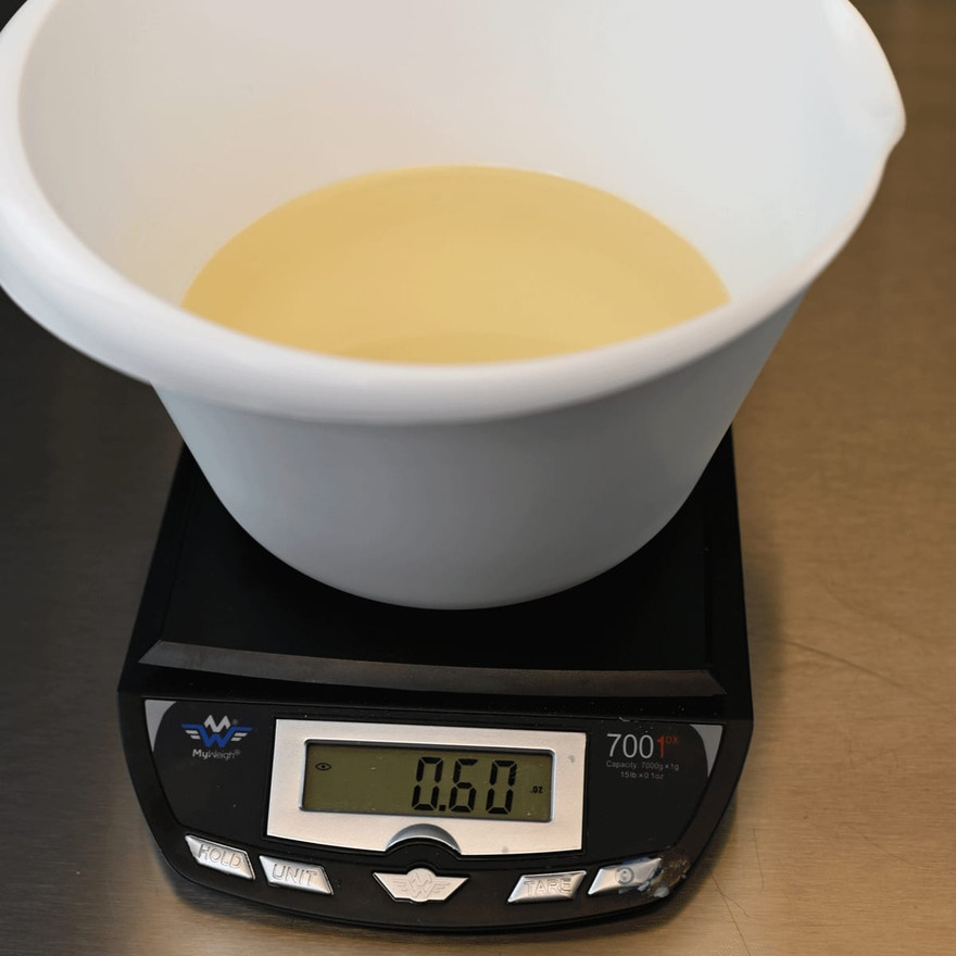 A bowl of melted clear soap base on a scale
