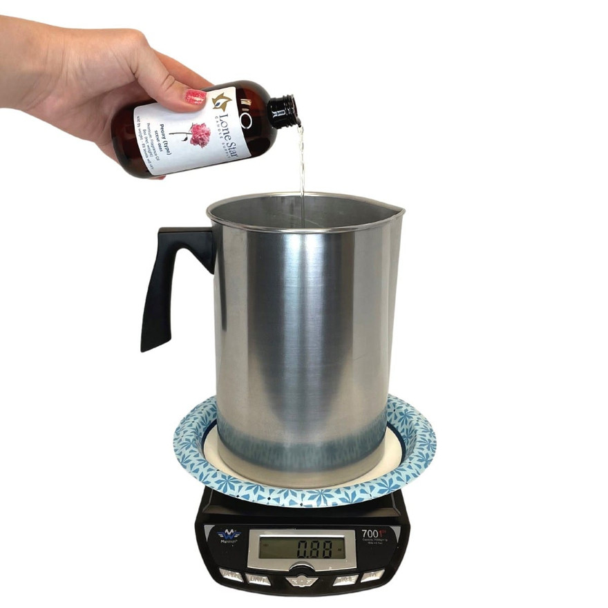 Hand pouring Lone Star Peony fragrance oil into a pitcher on a digital scale reading 0.88